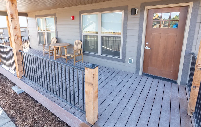 Metal deck railing running along new gray decking