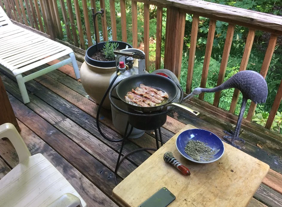 Grill and table on a timber deck behind a railing