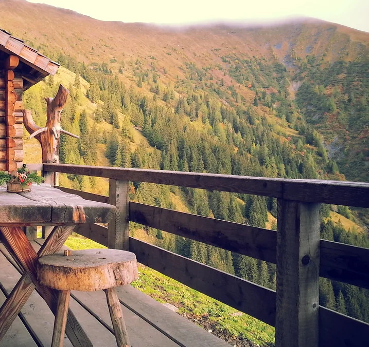 Deck table and railing looking out over a wooded hillside